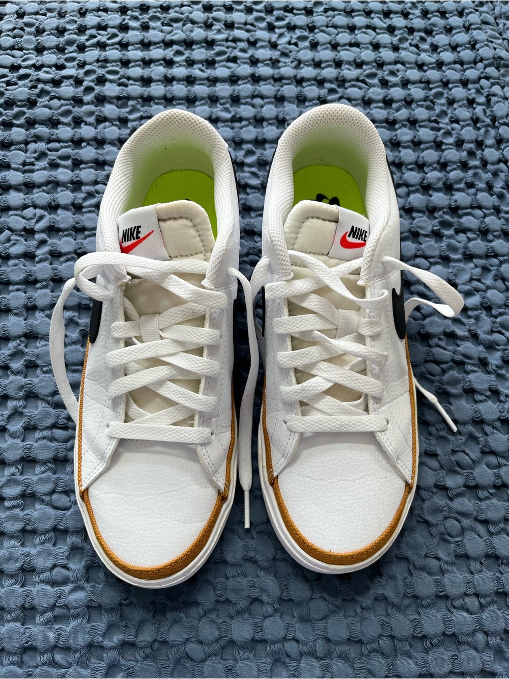 Nike White Low-Top Sneakers with Black Swoosh and Gold Accent